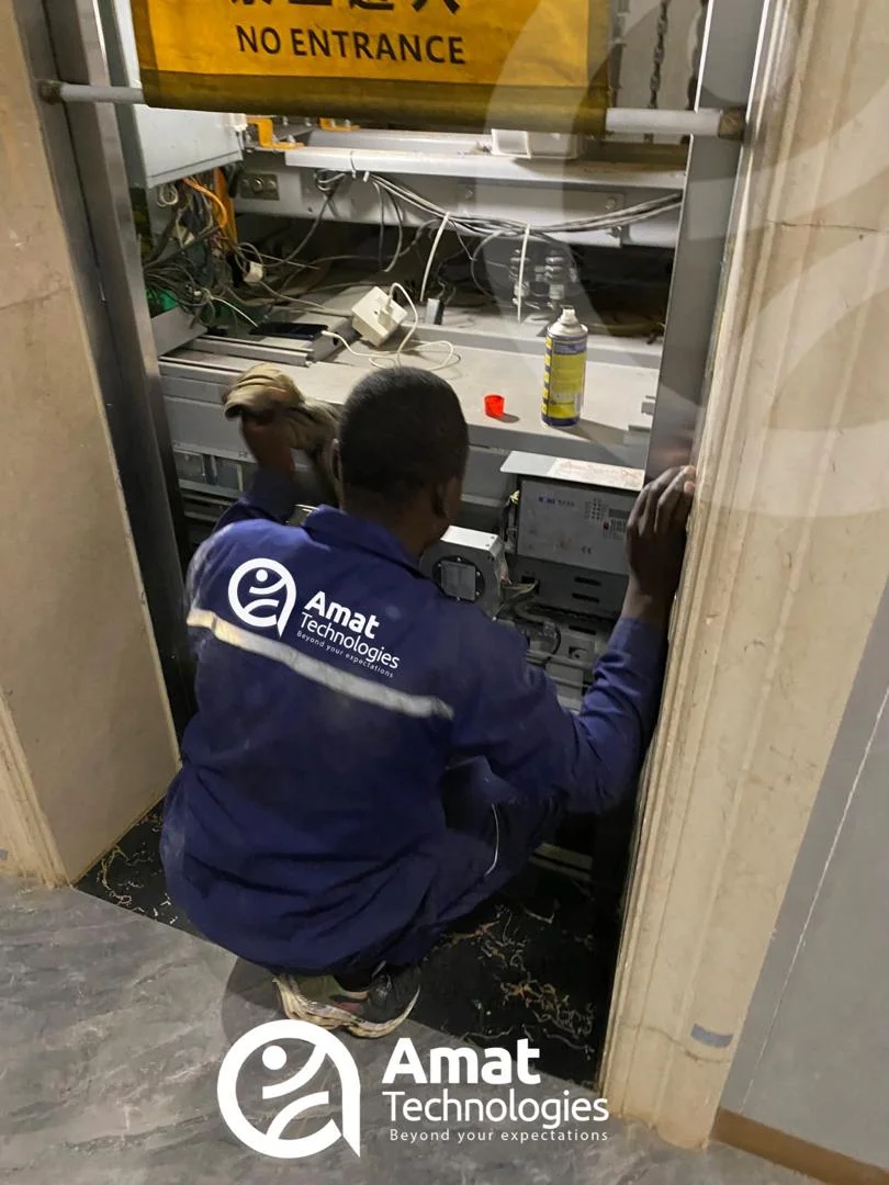 AMAT technician servicing elevator shaft control gear