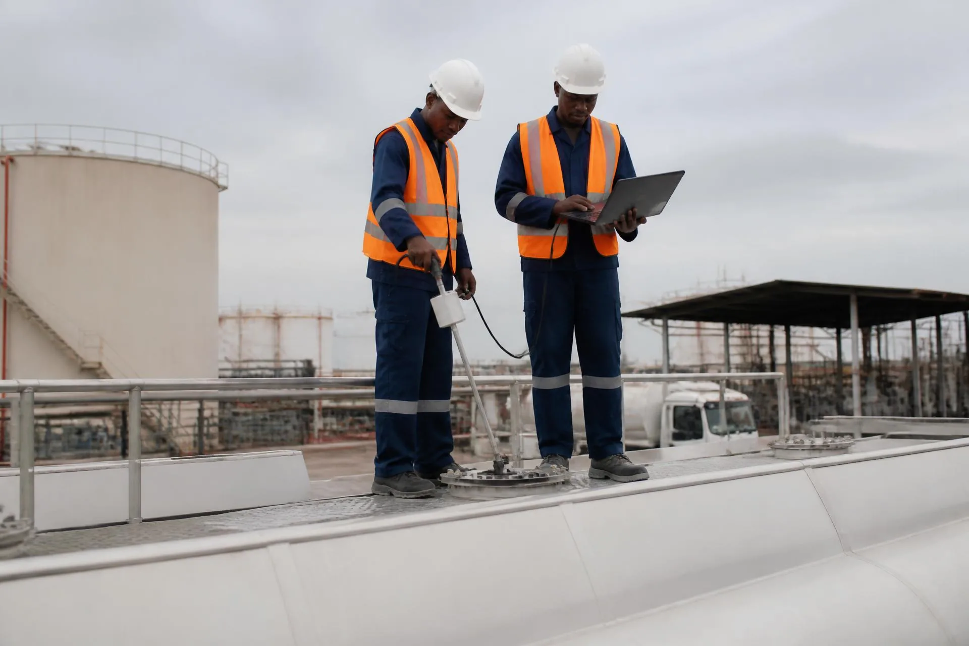 AMAT field engineer calibrating an Escort capacitance fuel sensor on top of a blue tanker